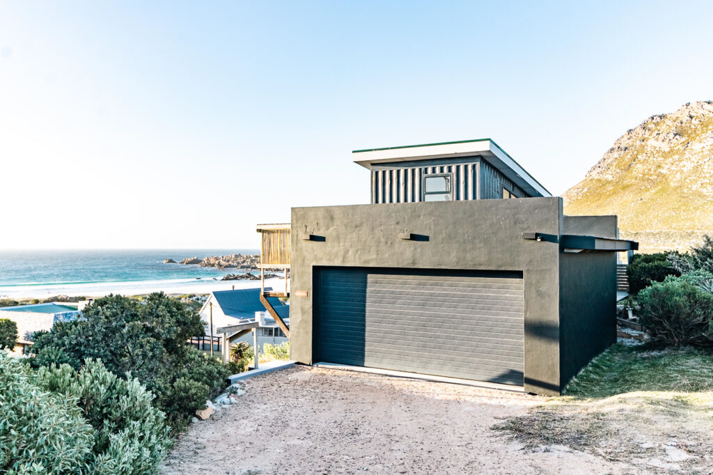 The Red Door property exterior framed by coastal vegetation