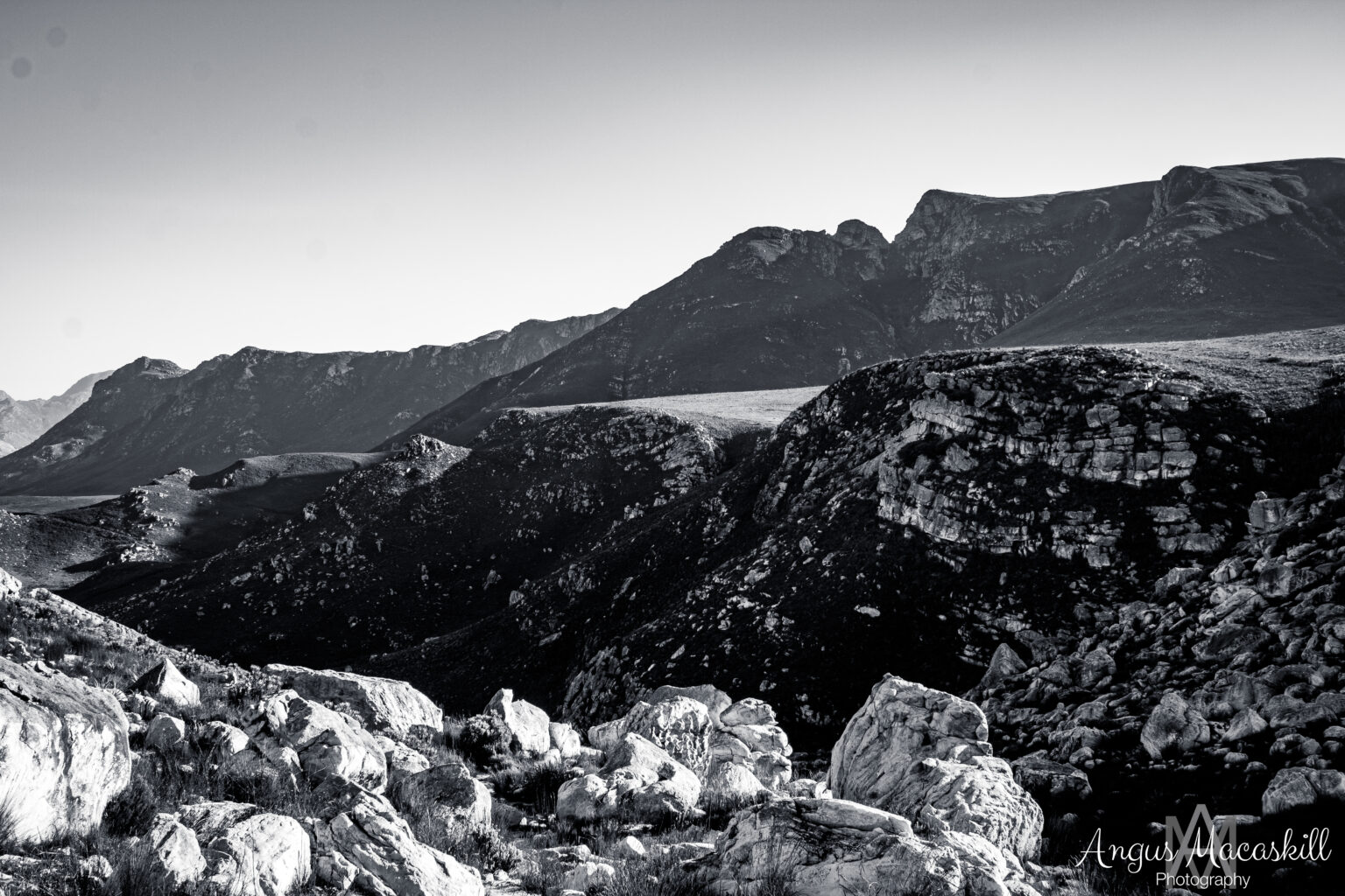 Rocky mountain ridges and layered terrain photographed in black and white