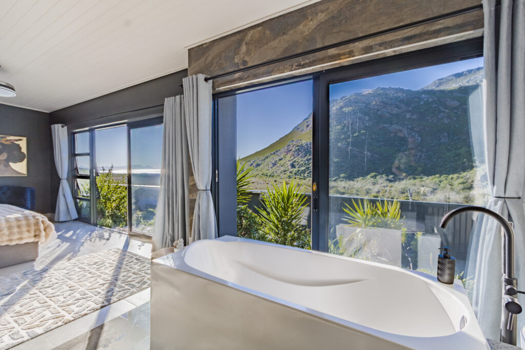Freestanding bath beside floor-to-ceiling windows overlooking the mountains at Red River Valley
